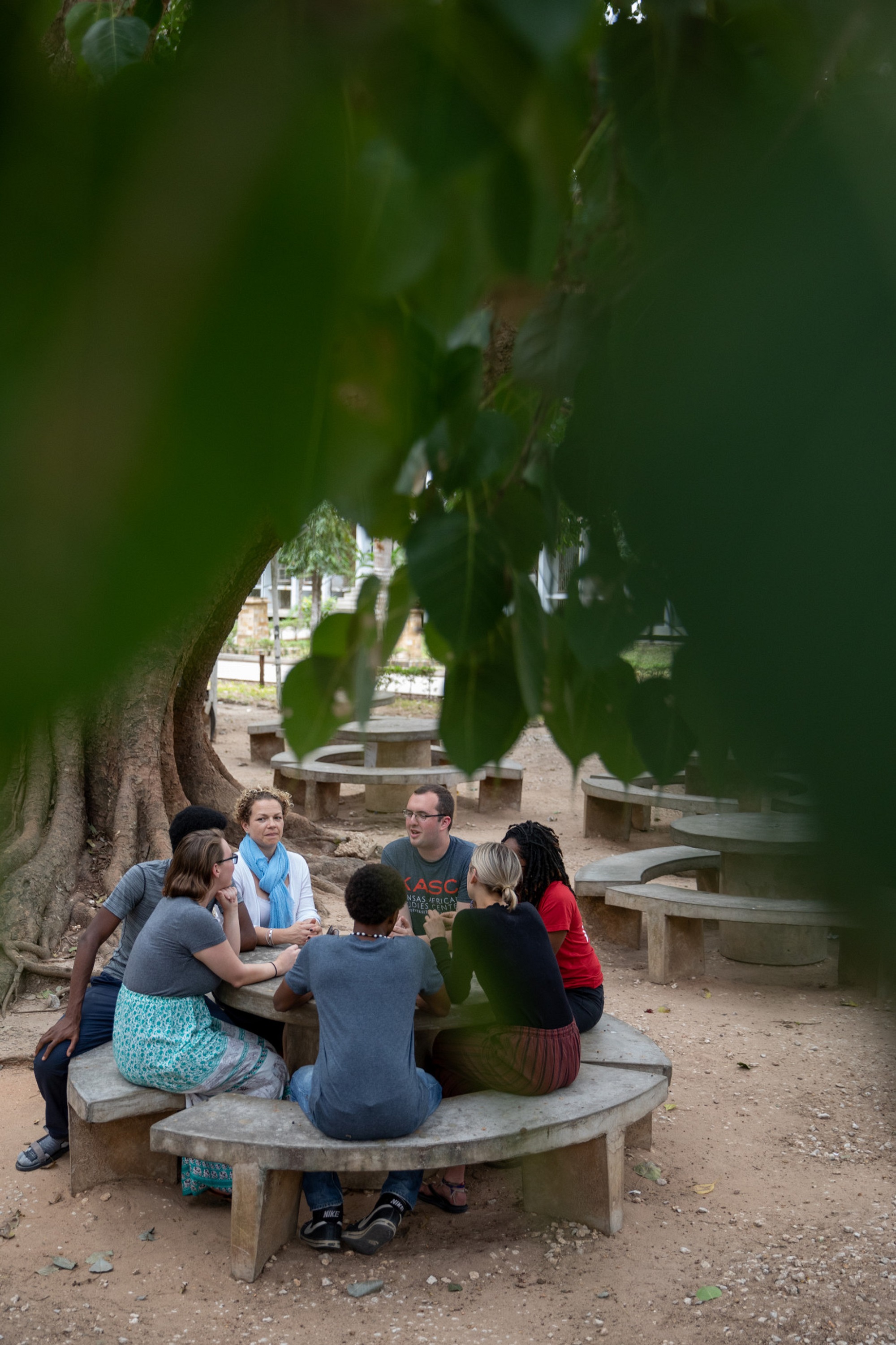 A group of students sitting around a stone table and bench