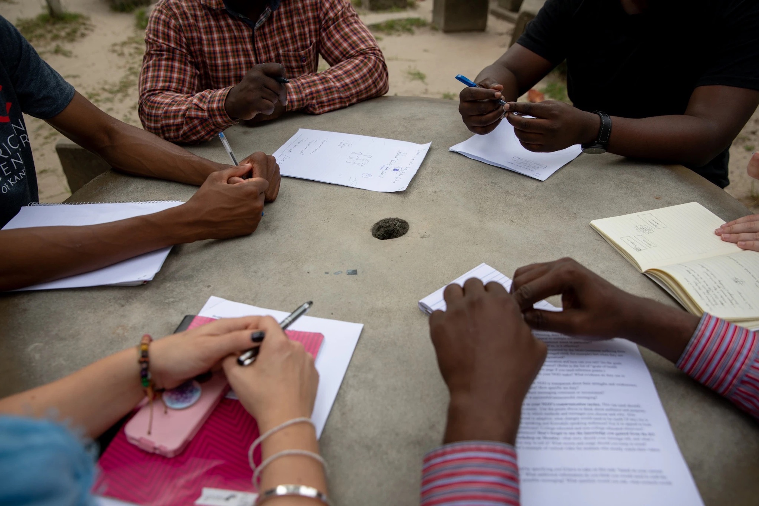 Collaborators' hands on a table as they work and discuss