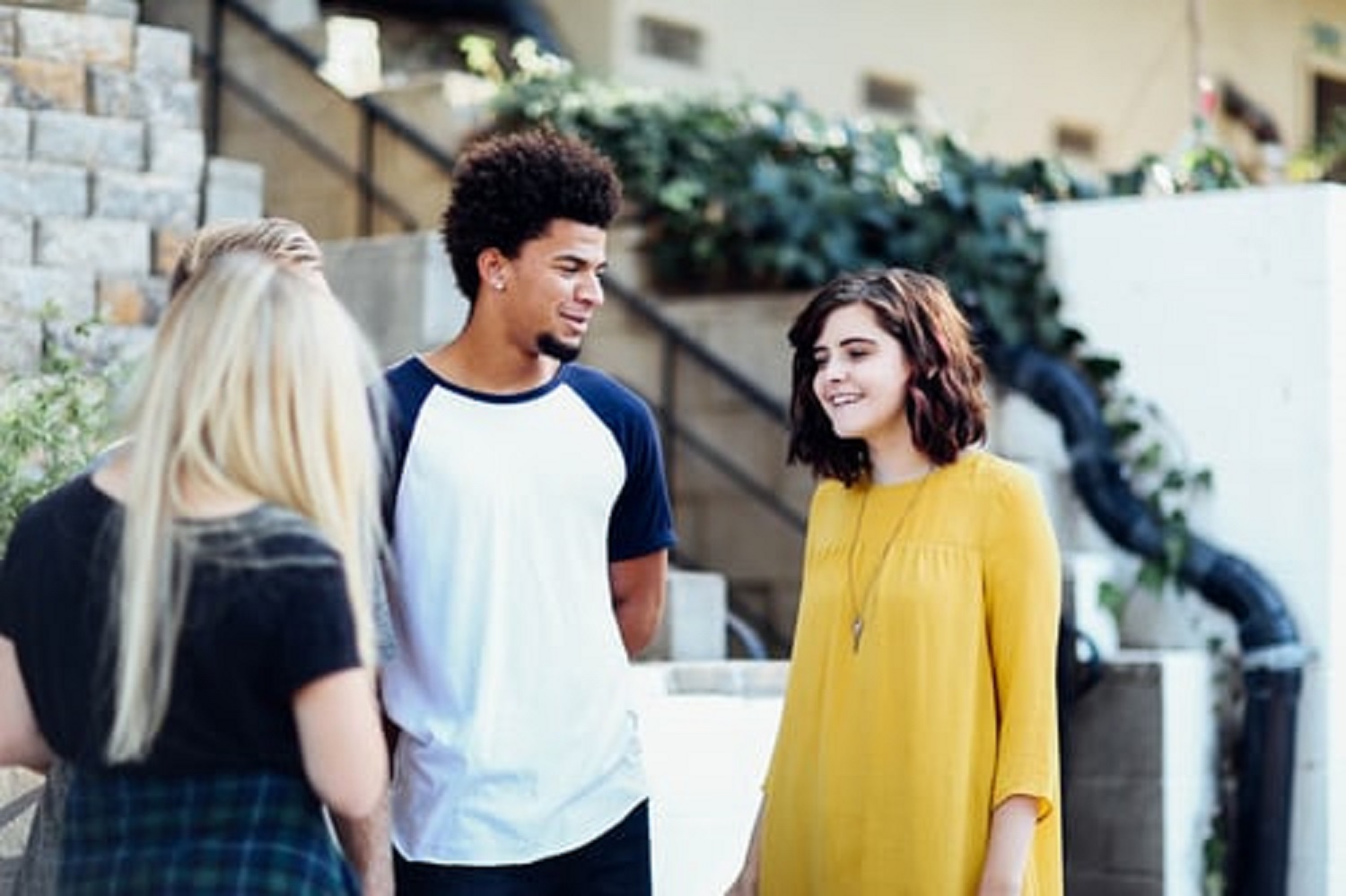 Three students chatting outside a building